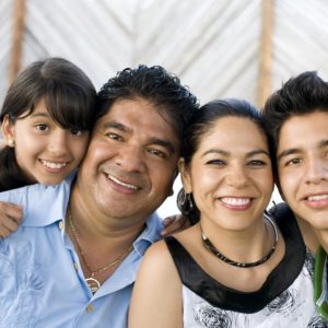 Smiling family of parents with their two children representing parentage declaration