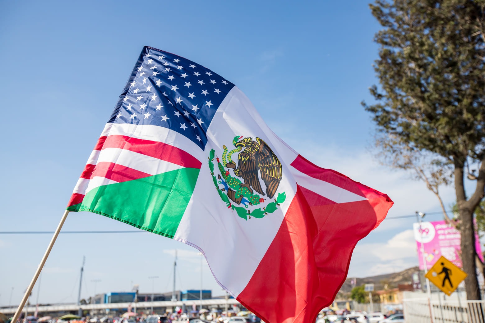 United States and Mexican flags waving at a border crossing